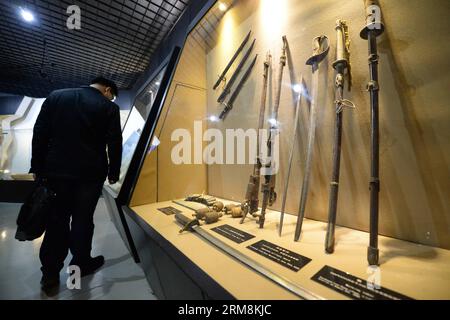 (140418) -- HARBIN, 18 avril 2014 (Xinhua) -- Un homme regarde des armes utilisées par des envahisseurs japonais dans un musée de l'unité 731 à Harbin, capitale de la province du Heilongjiang du nord-est de la Chine, le 18 avril 2014. L'unité 731 était une unité de recherche sur la guerre biologique et chimique basée à Harbin de l'armée japonaise pendant la Seconde Guerre mondiale. Les ruines de l'unité 731 à Harbin sont des preuves des atrocités commises en temps de guerre par les envahisseurs japonais en Chine. Les membres de l'unité 731 ont mené une série d'expériences humaines qui ont soumis les victimes à des vivisections, des attaques contre la guerre des germes, des essais d'armes et d'autres formes de torture. Le 18 avril est le I Banque D'Images