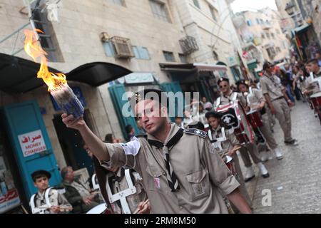 (140420) -- BETHLÉEM, 20 avril 2014 (Xinhua) - des éclaireurs palestiniens se produisent alors qu'ils participent à la cérémonie du Saint feu devant l'église de la Nativité, construite sur le site traditionnel de la naissance de Jésus à Bethléem, le 19 avril 2014. Au cours de la cérémonie annuelle, les plus hauts clercs entrent dans l'Aédicule, la petite chambre marquant le site de la tombe de Jésus dans l'église du Saint-Sépulcre de Jérusalem, traditionnellement considérée comme le lieu de sépulture de Jésus-Christ. Ils émergent après pour révéler des bougies allumées avec le feu Saint dit être miraculeusement allumé comme un message aux fidèles du ciel. Le deta Banque D'Images