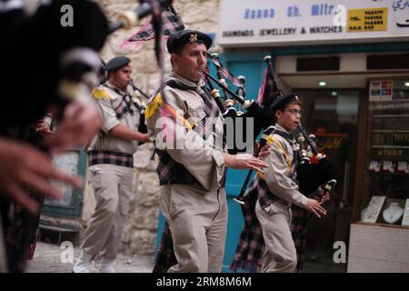 (140420) -- BETHLÉEM, 20 avril 2014 (Xinhua) - des éclaireurs palestiniens se produisent alors qu'ils participent à la cérémonie du Saint feu devant l'église de la Nativité, construite sur le site traditionnel de la naissance de Jésus à Bethléem, le 19 avril 2014. Au cours de la cérémonie annuelle, les plus hauts clercs entrent dans l'Aédicule, la petite chambre marquant le site de la tombe de Jésus dans l'église du Saint-Sépulcre de Jérusalem, traditionnellement considérée comme le lieu de sépulture de Jésus-Christ. Ils émergent après pour révéler des bougies allumées avec le feu Saint dit être miraculeusement allumé comme un message aux fidèles du ciel. Le deta Banque D'Images