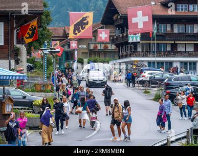 Touristes marchant dans le village de Lauterbrunnen, canton de Berne, Suisse. Banque D'Images