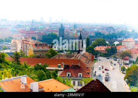 Vue sur les toits de Prague vers le célèbre pont Charles enjambant la rivière Vltava, avec l'horizon de la vieille ville en arrière-plan Banque D'Images