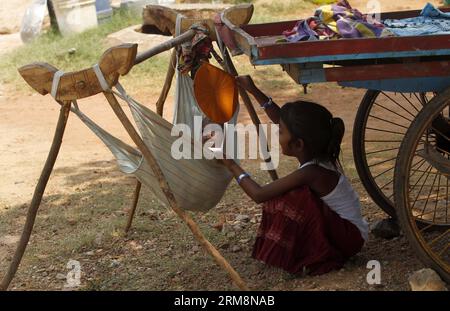 (140422) -- BHUBANESWAR, 21 avril 2014 (Xinhua) -- Une fillette vivant dans la rue branle un ventilateur alors que son petit frère dort alors que leurs parents vont travailler par un après-midi chaud dans la capitale de l État indien oriental d Orissa, Bhubaneswar, Inde, le 21 avril 2014. (Xinhua/Stringer) INDIA-BHUBANESWAR-DAILY LIFE PUBLICATIONxNOTxINxCHN Bhubaneswar avril 21 2014 XINHUA une fille vivant dans la rue balançait un supporter comme son petit frère dort alors que leurs parents vont travailler À un midi chaud dans l'État indien de l'est Orissa S capitale Bhubaneswar Inde avril 21 2014 XINHUA Stringer Inde Bhubaneswar Dail Banque D'Images