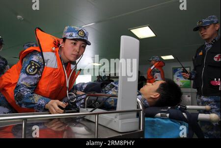 (140423) -- QINGDAO, 23 avril 2014 (Xinhua) -- des membres du personnel médical soignent les blessés lors des exercices maritimes multipays au large de Qingdao, dans la province du Shandong, dans l est de la Chine, le 23 avril 2014. Dix-neuf navires, sept hélicoptères et corps maritimes de huit pays, dont la Chine, le Bangladesh, le Pakistan, Singapour, l'Indonésie, l'Inde, la Malaisie et le Brunei ont été organisés en trois groupes de travail pour mener les exercices baptisés coopération maritime - 2014 . (Xinhua/Huang Yuping) (mp) EXERCICES MARITIMES CHINE-QINGDAO-MULTI-PAYS (CN ) PUBLICATIONxNOTxINxCHN Qingdao avril Banque D'Images