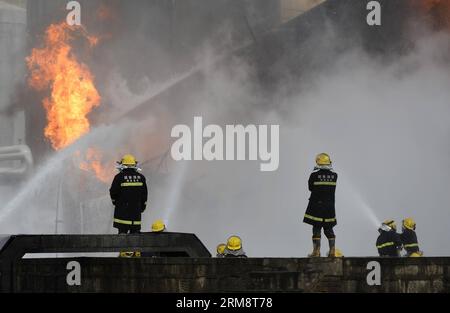 (140426) -- YAN AN, 26 avril 2014 (Xinhua) -- les pompiers tentent d'éteindre le feu sur le site de l'explosion éclair de trois réservoirs de brut léger à l'usine de raffinerie du Groupe pétrolier Shaanxi Yancheng dans la ville de Yan an an, dans la province du Shaanxi au nord-ouest de la Chine, le 26 avril 2014. L'incident s'est produit à 1:48 heures du matin le 26 avril, brûlant trois personnes à la raffinerie. Les sauveteurs se sont précipités pour combattre le feu et envoyer les blessés dans un hôpital local. À partir de 6 heures du matin, les sauveteurs ont maîtrisé le feu et installé cinq barrages d'interception aux tronçons supérieurs de la rivière Luohe voisine pour prévenir les risques de pollution. LOC Banque D'Images