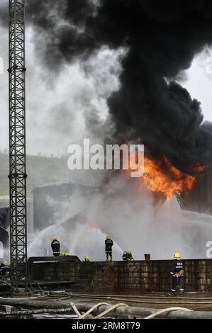 (140426) -- YAN AN, 26 avril 2014 (Xinhua) -- les pompiers tentent d'éteindre le feu sur le site de l'explosion éclair de trois réservoirs de brut léger à l'usine de raffinerie du Groupe pétrolier Shaanxi Yancheng dans la ville de Yan an an, dans la province du Shaanxi au nord-ouest de la Chine, le 26 avril 2014. L'incident s'est produit à 1:48 heures du matin le 26 avril, brûlant trois personnes à la raffinerie. Les sauveteurs se sont précipités pour combattre le feu et envoyer les blessés dans un hôpital local. À partir de 6 heures du matin, les sauveteurs ont maîtrisé le feu et installé cinq barrages d'interception aux tronçons supérieurs de la rivière Luohe voisine pour prévenir les risques de pollution. LOC Banque D'Images