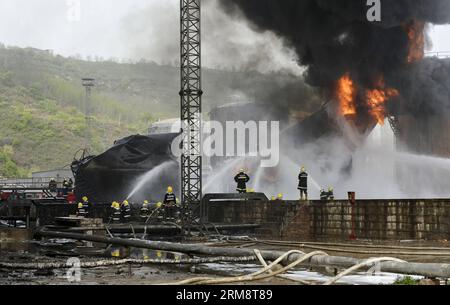 (140426) -- YAN AN, 26 avril 2014 (Xinhua) -- les pompiers tentent d'éteindre le feu sur le site d'une explosion éclair sur trois réservoirs de brut léger à l'usine de raffinage du Shaanxi Yancheng Petroleum Group dans la ville de Yan an an, dans la province du Shaanxi au nord-ouest de la Chine, le 26 avril 2014. L'incident s'est produit à 1:48 heures du matin le 26 avril, brûlant trois personnes à la raffinerie. Les sauveteurs se sont précipités pour combattre le feu et envoyer les blessés dans un hôpital local. À partir de 6 heures du matin, les sauveteurs ont maîtrisé le feu et installé cinq barrages d'interception aux tronçons supérieurs de la rivière Luohe voisine pour prévenir les risques de pollution. L Banque D'Images