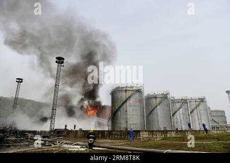 (140426) -- YAN AN, 26 avril 2014 (Xinhua) -- les pompiers tentent d'éteindre le feu sur le site de l'explosion éclair de trois réservoirs de brut léger à l'usine de raffinerie du Groupe pétrolier Shaanxi Yancheng dans la ville de Yan an an, dans la province du Shaanxi au nord-ouest de la Chine, le 26 avril 2014. L'incident s'est produit à 1:48 heures du matin le 26 avril, brûlant trois personnes à la raffinerie. Les sauveteurs se sont précipités pour combattre le feu et envoyer les blessés dans un hôpital local. À partir de 6 heures du matin, les sauveteurs ont maîtrisé le feu et installé cinq barrages d'interception aux tronçons supérieurs de la rivière Luohe voisine pour prévenir les risques de pollution. LOC Banque D'Images