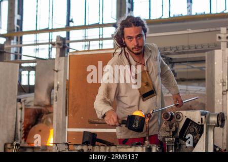 Karlovy Vary, République tchèque - 10 août 2017 : souffleur de verre professionnel moulant un morceau de verre chaud dans l'usine du Moser Museum of Glass Banque D'Images