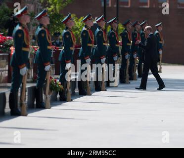 (140508) -- MOSCOU, 8 mai 2014 (Xinhua) -- le président russe Vladimir Poutine présente des fleurs aux soldats qui ont sacrifié leur vie dans la Grande Guerre patriotique lors d'une cérémonie de dépôt de gerbes dans le jardin Alexandrovsky à Moscou, Russie, le 8 mai 2014. Poutine et d'autres officiels ont déposé une gerbe sur la tombe du Soldat inconnu lors de la cérémonie à la veille du 69e jour de la victoire, lorsque le pays célèbre la victoire sur l'Allemagne nazie pendant la Seconde Guerre mondiale (Xinhua/Dai Tianfang) (dzl) RUSSIE-MOSCOU-POUTINE-JOUR DE LA VICTOIRE-CÉRÉMONIE DE DÉPÔT DE COURONNE PUBLICATIONxNOTxINxCHN Moscou Mai 8 2014 XINHUA Russi Banque D'Images