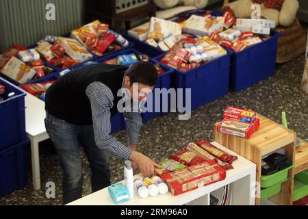 Un bénévole emballe de la nourriture pour les personnes dans le besoin au Centre d’accueil et de solidarité de la municipalité d’Athènes (KYADA) dans le centre-ville d’Athènes, Grèce, le 9 mai 2014. La crise de la dette en cours en Grèce a porté à 20 000 le nombre de personnes sollicitant l’aide de la KYADA, contre 3 000 avant la crise. (Xinhua photo/Marios Lolos) GRÈCE-ATHÈNES-CHARITÉ-BÉNÉVOLES-DISTRIBUTION ALIMENTAIRE PUBLICATIONxNOTxINxCHN un volontaire emballe de la nourriture pour les célébrités dans le besoin au Centre d'accueil et de solidarité de la municipalité d'Athènes dans le centre d'Athènes en Grèce LE 9 2014 mai la crise de la dette en cours dans GRE Banque D'Images