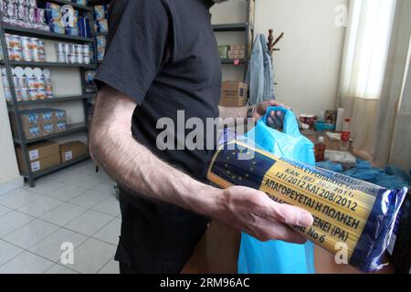 Un bénévole emballe de la nourriture pour les personnes dans le besoin au Centre d’accueil et de solidarité de la municipalité d’Athènes (KYADA) dans le centre-ville d’Athènes, Grèce, le 9 mai 2014. La crise de la dette en cours en Grèce a porté à 20 000 le nombre de personnes sollicitant l’aide de la KYADA, contre 3 000 avant la crise. (Xinhua photo/Marios Lolos) GRÈCE-ATHÈNES-CHARITÉ-BÉNÉVOLES-DISTRIBUTION ALIMENTAIRE PUBLICATIONxNOTxINxCHN un volontaire emballe de la nourriture pour les célébrités dans le besoin au Centre d'accueil et de solidarité de la municipalité d'Athènes dans le centre d'Athènes en Grèce LE 9 2014 mai la crise de la dette en cours dans GRE Banque D'Images