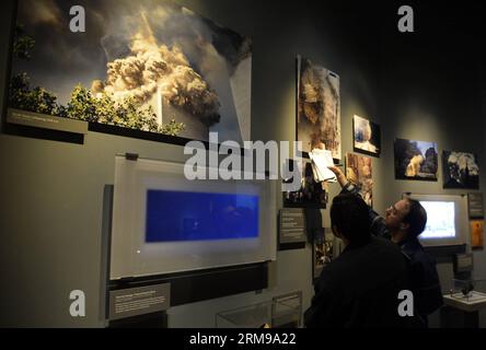 (140514) -- NEW YORK, 14 mai 2014 (Xinhua) -- les gens regardent des expositions lors d'une avant-première du National September 11 Memorial Museum à New York, le 14 mai 2014. Le Musée commémoratif national du 11 septembre sera la principale institution du pays chargée d examiner les répercussions des événements du 9 septembre 11, de documenter l impact de ces événements et d explorer l importance continue du 11 septembre 2001. Le Musée a 110 000 pieds carrés d'espace d'exposition situé dans le cœur archéologique du site du World Trade Center - racontant l'histoire de 9/11 à travers des expositions multimédias, des archives Banque D'Images