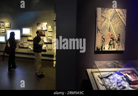 (140514) -- NEW YORK, 14 mai 2014 (Xinhua) -- les gens regardent des expositions lors d'une avant-première du National September 11 Memorial Museum à New York, le 14 mai 2014. Le Musée commémoratif national du 11 septembre sera la principale institution du pays chargée d examiner les répercussions des événements du 9 septembre 11, de documenter l impact de ces événements et d explorer l importance continue du 11 septembre 2001. Le Musée a 110 000 pieds carrés d'espace d'exposition situé dans le cœur archéologique du site du World Trade Center - racontant l'histoire de 9/11 à travers des expositions multimédias, des archives Banque D'Images