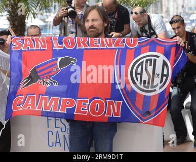 (140518) -- CANNES, 18 mai 2014 (Xinhua) -- l'acteur danois-américain Viggo Mortensen tient le drapeau du club de football de San Lorenzo de Almagro lors du photocall pour Jauja au 67e Festival de Cannes à Cannes, France, le 18 mai 2014. Le film est présenté dans la section un certain regard du festival qui se déroule du 14 au 25 mai. (Xinhua/Ye Pingfan) (zjl) FRANCE-CANNES-FILM FESTIVAL-JAUJA-PHOTO CALL PUBLICATIONxNOTxINxCHN Cannes Mai 18 2014 XINHUA l'acteur danois Viggo Mortensen tient le drapeau du San Lorenzo de Almagro football Club lors de l'appel photo du 67e Cannes fil Banque D'Images