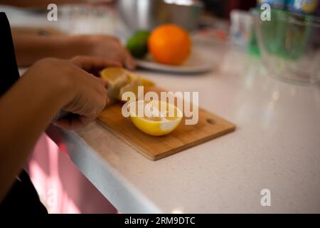 gros plan. les mains des enfants coupent des agrumes pour faire de la limonade lors d'un cours de cuisine Banque D'Images