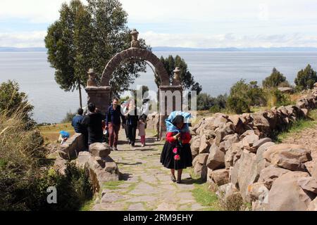 (140520) -- PUNO, 20 mai 2014 (Xinhua) -- Une femme marche sur une route sur l'île flottante Taquile au lac Titicaca, dans la région de Puno, Pérou, le 13 mai 2014. Le lac Titicaca et ses îles flottantes dans la région de Puno au Pérou ont non seulement des attractions naturelles, mais aussi une culture unique en raison du peuple Quechua de Juliaca qui y vit. Le lac Titicaca est situé dans le plateau de Collao, avec les îles de Luna, Taquile, Amantani, Uros et Suriqui. (Xinhua/Luis Camacho)(zhf) PERU-PUNO-TITICACA LAKE-FLOATING ISLAND PUBLICATIONxNOTxINxCHN Puno Mai 20 2014 XINHUA une femme marche SUR une route SUR le Taqu Banque D'Images