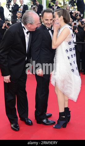 (140520) -- CANNES, 20 mai 2014 (Xinhua) -- l'actrice française Marion Cotillard (à droite) murmure avec l'acteur belge Fabrizio Rongione (C) dans le rôle du réalisateur belge Luc Dardenne à leur arrivée pour la projection de deux jours, une nuit ( deux jours, une nuit ) lors du 67e Festival de Cannes, à Cannes, France, le 20 mai 2014. Le film est présenté dans la compétition officielle du festival qui se déroule du 14 au 25 mai. (Xinhua/Ye Pingfan) FRANCE-CANNES-FILM FESTIVAL-DEUX JOURS UNE NUIT-TAPIS ROUGE PUBLICATIONxNOTxINxCHN Cannes Mai 20 2014 XINHUA actrice française Marion Cotillard r CHUCHOTE avec esprit Banque D'Images