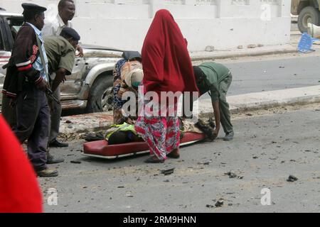 (140524) -- MOGADISCIO, 24 mai 2014 (Xinhua) -- des agents de sécurité somaliens transportent une victime devant le Parlement somalien à Mogadiscio, le 24 mai 2014. Au moins 9 personnes ont été tuées et 16 autres blessées après qu'une voiture piégée a explosé devant le Parlement somalien à Mogadiscio, suivi d'échanges de coups de feu nourris, a déclaré la police. (Xinhua/Faisal ISSE) (COUVERTURE VISUELLE DES SCÈNES DE BLESSURES OU DE DÉCÈS DES RÉDACTEURS EN CHEF) SOMALI-MOGADISCIO-ATTACK PUBLICATIONxNOTxINxCHN Mogadiscio Mai 24 2014 les agents de sécurité somaliens de XINHUA transportent une victime devant le Parlement somalien à Mogadiscio Mai 24 2014 au moins 9 Celebriti Banque D'Images