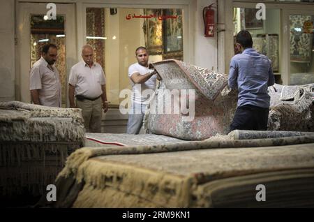 (140526) -- TÉHÉRAN, 26 mai 2014 (Xinhua) -- les gens choisissent des tapis dans un bazar à tapis dans le centre-ville de Téhéran, Iran, le 26 mai 2014. Le marché international des exportations de tapis iraniens demeure stable, malgré une récession sur le marché intérieur. Environ un million de personnes sont impliquées dans l'industrie des tapis tissés à la main à travers le pays. (Xinhua/Ahmad Halabisaz) IRAN-TÉHÉRAN-INDUSTRIE DU TAPIS PUBLICATIONxNOTxINxCHN TÉHÉRAN Mai 26 2014 les célébrités de XINHUA choisissent des tapis À un Carpet Bazaar dans le centre-ville de TÉHÉRAN Iran EN mai 26 2014 le marché international pour l'exportation de tapis S reste stable malgré une récession dans le Banque D'Images