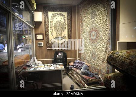 (140526) -- TÉHÉRAN, 26 mai 2014 (Xinhua) -- Un homme repose sur des tapis dans un bazar à tapis dans le centre-ville de Téhéran, Iran, le 26 mai 2014. Le marché international des exportations de tapis iraniens demeure stable, malgré une récession sur le marché intérieur. Environ un million de personnes sont impliquées dans l'industrie des tapis tissés à la main à travers le pays. (Xinhua/Ahmad Halabisaz) IRAN-TÉHÉRAN-INDUSTRIE DU TAPIS PUBLICATIONxNOTxINxCHN TÉHÉRAN Mai 26 2014 XINHUA un homme repose SUR des tapis dans un bazar de tapis au centre-ville de TÉHÉRAN Iran en mai 26 2014 le marché international pour l'exportation de tapis S Iran reste stable malgré une récession dans le DO Banque D'Images