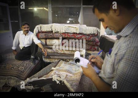 (140526) -- TÉHÉRAN, 26 mai 2014 (Xinhua) -- Un travailleur se repose assis sur des tapis dans un bazar à tapis dans le centre-ville de Téhéran, en Iran, le 26 mai 2014. Le marché international des exportations de tapis iraniens demeure stable, malgré une récession sur le marché intérieur. Environ un million de personnes sont impliquées dans l'industrie des tapis tissés à la main à travers le pays. (Xinhua/Ahmad Halabisaz) IRAN-TÉHÉRAN-INDUSTRIE DU TAPIS PUBLICATIONxNOTxINxCHN TÉHÉRAN Mai 26 2014 XINHUA un travailleur se repose assis SUR des tapis DANS un bazar À tapis au centre-ville de TÉHÉRAN Iran EN mai 26 2014 le marché international pour l'exportation de tapis en Iran S reste stable Banque D'Images