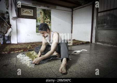 (140526) -- TÉHÉRAN, 26 mai 2014 (Xinhua) -- un travailleur iranien répare un tapis dans un bazar à tapis du centre-ville de Téhéran, Iran, le 26 mai 2014. Le marché international des exportations de tapis iraniens demeure stable, malgré une récession sur le marché intérieur. Environ un million de personnes sont impliquées dans l'industrie des tapis tissés à la main à travers le pays. (Xinhua/Ahmad Halabisaz) IRAN-TÉHÉRAN-INDUSTRIE DU TAPIS PUBLICATIONxNOTxINxCHN TÉHÉRAN Mai 26 2014 XINHUA à un travailleur iranien répare un tapis dans un bazar À tapis dans le centre-ville DE TÉHÉRAN Iran en mai 26 2014 le marché international pour l'Iran S Carpet Export reste stable malgré A. Banque D'Images