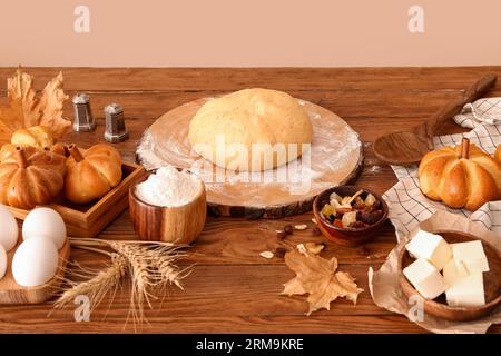 Pâte crue et ingrédients pour préparer des petits pains en forme de citrouille sur la table Banque D'Images