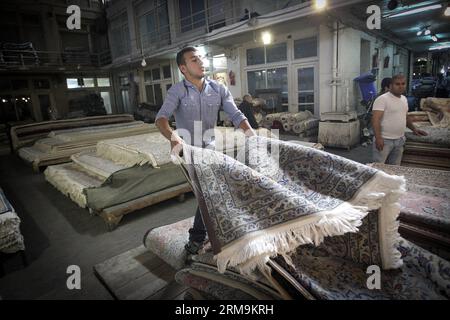 (140526) -- TÉHÉRAN, 26 mai 2014 (Xinhua) -- un travailleur arrange des tapis dans un bazar à tapis dans le centre-ville de Téhéran, Iran, le 26 mai 2014. Le marché international des exportations de tapis iraniens demeure stable, malgré une récession sur le marché intérieur. Environ un million de personnes sont impliquées dans l'industrie des tapis tissés à la main à travers le pays. (Xinhua/Ahmad Halabisaz) IRAN-TÉHÉRAN-INDUSTRIE DU TAPIS PUBLICATIONxNOTxINxCHN TÉHÉRAN Mai 26 2014 XINHUA un travailleur arrange des tapis dans un bazar à tapis au centre-ville de TÉHÉRAN Iran EN mai 26 2014 le marché international pour l'exportation de tapis en Iran S reste stable malgré une récession Banque D'Images