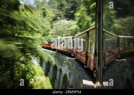 HIMACHAL PRADESH, 28 mai 2013 (Xinhua) -- Un train est en service sur le chemin de fer Kalka-Shimla dans le nord de l'Inde, le 28 mai 2014. Le chemin de fer Kalka-Shimla est un chemin de fer à voie étroite de 762 mm dans le nord-ouest de l'Inde de l'Himachal Pradesh voyageant le long d'une route principalement montagneuse de Kalka à Shimla. Il est connu pour ses vues spectaculaires sur les collines et les villages environnants. Le chemin de fer long de 96 km a été construit depuis 1898 pour fournir un service à la ville montagneuse de Shimla. Trois chemins de fer encore pleinement opérationnels, le Darjeeling Himalayan Railway au Bengale occidental de l Inde, le Nilgiri Mountain Railway Banque D'Images