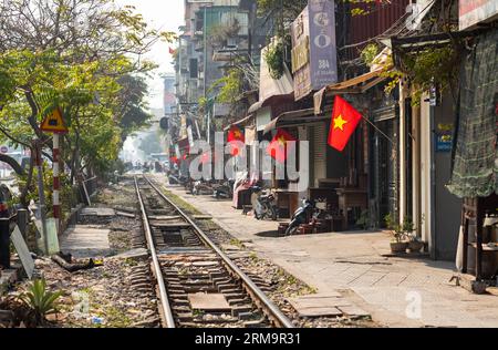 Les drapeaux vietnamiens flottent dans le smog pollué le long de la principale ligne de chemin de fer nord-sud reliant Hanoi et Ho Chi Minh-ville comme il passe le long de L. Banque D'Images