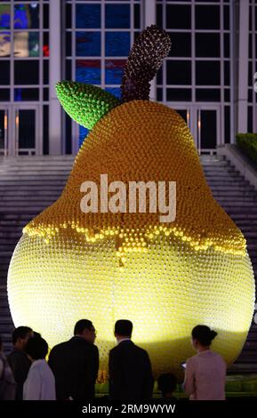 (140604) -- SHANGHAI, 4 juin 2014 (Xinhua) -- les gens regardent une sculpture de poire sur laquelle les canards en caoutchouc sont arrachés par des visiteurs à Shanghai, dans l'est de la Chine, le 4 juin 2014. La sculpture de poire, qui a été faite de plus de 15 000 canards en caoutchouc, a attiré une grande foule de visiteurs et beaucoup ont arraché les canards en caoutchouc loin de la poire, causant une perte de plus de 100 000 yuans (16 100 dollars américains), selon l'organisateur. L'incident a suscité un vif débat en ligne avec de nombreux internautes condamnant l'acte. (Xinhua/Lai Xinlin) (lfj) CHINE-SHANGHAI-POIRE SCULPTURE-CAOUTCHOUC CANARD-PERTE (CN) PUBLICATIONxNOT Banque D'Images