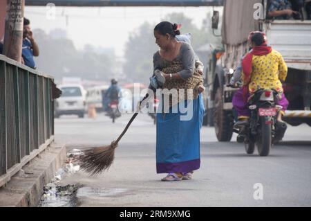 (140605) -- KATMANDOU, 5 juin 2014 (Xinhua) -- Une femme portant un enfant nettoie la route à l'occasion de la Journée mondiale de l'environnement à Katmandou, Népal, le 5 juin 2014. La Journée de l'environnement est célébrée avec le thème "élever votre voix pas le niveau de la mer dans le monde entier cette année. (Xinhua/Pratap Thapa) NÉPAL-KATMANDOU-JOURNÉE MONDIALE DE L'ENVIRONNEMENT PUBLICATIONxNOTxINxCHN Katmandou juin 5 2014 XINHUA une femme portant un enfant nettoie la route LORS DE la Journée mondiale de l'environnement à Katmandou Népal juin 5 2014 la Journée de l'environnement EST célébrée avec le thème "élever votre voix pas le niveau de la mer" cette année XINHUA Prata Banque D'Images