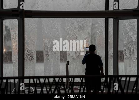 (140610) -- PÉKIN, 10 juin 2014 (Xinhua) -- Un touriste prend des photos d'une averse au Centre national des arts de la scène (NCPA) à Pékin, capitale de la Chine, le 10 juin 2014. Une pluie torrentielle a frappé la capitale mardi après-midi. (Xinhua/Luo Xiaoguang) (hdt) CHINA-BEIJING-RAINFALL (CN) PUBLICATIONxNOTxINxCHN Beijing juin 10 2014 XINHUA un touriste prend des photos d'une averse AU Centre national des arts de la scène NCPA à Beijing capitale de la Chine juin 10 2014 une pluie torrentielle a frappé la capitale mardi midi XINHUA Luo Xiaoguang HDT Chine Beijing pluie CN PUBLICATIO Banque D'Images