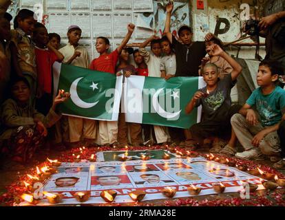 (140611) -- KARACHI, 11 juin 2014 (Xinhua) -- des Pakistanais se sont rassemblés autour de photos de responsables de la sécurité qui ont donné leur vie lors d'une attaque de militants contre l'aéroport de Karachi lors d'une cérémonie de veillée dans la ville portuaire de Karachi, dans le sud du Pakistan, le 11 juin 2014. Au moins 38 personnes, dont 10 militants, ont été tuées dans l'attaque de l'aéroport international Jinnah de Karachi tard dimanche soir. (Xinhua/Arshad) (cy) PAKISTAN-KARACHI-ATTACK-MOUORNING PUBLICATIONxNOTxINxCHN Karachi juin 11 2014 des célébrités pakistanaises de XINHUA se sont rassemblées autour de photos de responsables de la sécurité qui ont donné leur vie dans l'attaque militante O. Banque D'Images