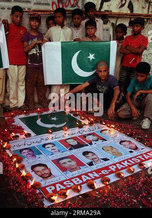 (140611) -- KARACHI, 11 juin 2014 (Xinhua) -- des Pakistanais se sont rassemblés autour de photos de responsables de la sécurité qui ont donné leur vie lors d'une attaque de militants contre l'aéroport de Karachi lors d'une cérémonie de veillée dans la ville portuaire de Karachi, dans le sud du Pakistan, le 11 juin 2014. Au moins 38 personnes, dont 10 militants, ont été tuées dans l'attaque de l'aéroport international Jinnah de Karachi tard dimanche soir. (Xinhua/Arshad) (cy) PAKISTAN-KARACHI-ATTACK-MOUORNING PUBLICATIONxNOTxINxCHN Karachi juin 11 2014 des célébrités pakistanaises de XINHUA se sont rassemblées autour de photos de responsables de la sécurité qui ont donné leur vie dans l'attaque militante O. Banque D'Images