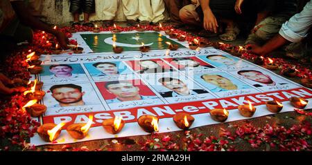 (140611) -- KARACHI, 11 juin 2014 (Xinhua) -- des Pakistanais se sont rassemblés autour de photos de responsables de la sécurité qui ont donné leur vie lors d'une attaque de militants contre l'aéroport de Karachi lors d'une cérémonie de veillée dans la ville portuaire de Karachi, dans le sud du Pakistan, le 11 juin 2014. Au moins 38 personnes, dont 10 militants, ont été tuées dans l'attaque de l'aéroport international Jinnah de Karachi tard dimanche soir. (Xinhua/Arshad) (cy) PAKISTAN-KARACHI-ATTACK-MOUORNING PUBLICATIONxNOTxINxCHN Karachi juin 11 2014 des célébrités pakistanaises de XINHUA se sont rassemblées autour de photos de responsables de la sécurité qui ont donné leur vie dans l'attaque militante O. Banque D'Images