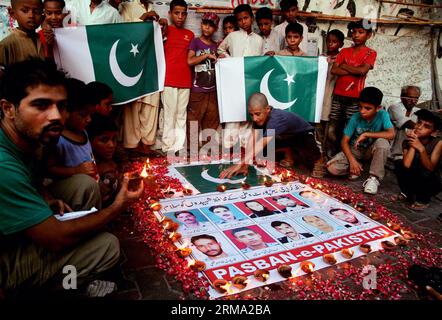 (140611) -- KARACHI, 11 juin 2014 (Xinhua) -- des Pakistanais se sont rassemblés autour de photos de responsables de la sécurité qui ont donné leur vie lors d'une attaque de militants contre l'aéroport de Karachi lors d'une cérémonie de veillée dans la ville portuaire de Karachi, dans le sud du Pakistan, le 11 juin 2014. Au moins 38 personnes, dont 10 militants, ont été tuées dans l'attaque de l'aéroport international Jinnah de Karachi tard dimanche soir. (Xinhua/Arshad) (cy) PAKISTAN-KARACHI-ATTACK-MOUORNING PUBLICATIONxNOTxINxCHN Karachi juin 11 2014 des célébrités pakistanaises de XINHUA se sont rassemblées autour de photos de responsables de la sécurité qui ont donné leur vie dans l'attaque militante O. Banque D'Images