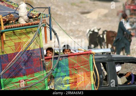 (140620) -- BANNU, 20 juin 2014 (Xinhua) -- des enfants pakistanais, fuyant une opération militaire dans l'agence tribale du Nord-Waziristan, sont assis dans un camion à leur arrivée à Bannu, au nord-ouest du Pakistan, le 20 juin 2014. Des hélicoptères de combat pakistanais ont pilonné des cibles militantes dans le nord-ouest du pays vendredi, tuant jusqu'à 20 rebelles, alors que le nombre de civils fuyant une offensive terrestre attendue a dépassé les 150 000, ont rapporté les médias locaux. (Xinhua/Ahmad sidique) PAKISTAN-BANNU-REFUGEES PUBLICATIONxNOTxINxCHN Bannu juin 20 2014 enfants pakistanais XINHUA fuyant une opération militaire dans l'Agence tribale du Nord Banque D'Images