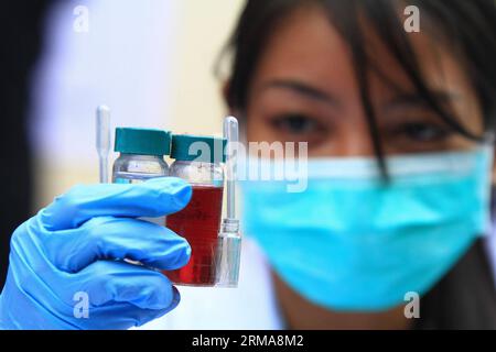 (140625) -- PROVINCE DE CAVITE, 25 juin 2014 (Xinhua) -- Un chimiste examine des produits chimiques qui seront utilisés pour tester des échantillons de drogues illicites confisqués par l'Agence philippine de lutte contre la drogue (PDEA) dans la province de Cavite, aux Philippines, le 25 juin 2014. La PDEA a détruit des drogues illégales confisquées d'une valeur de plus de 14,8 millions de dollars américains, composées de shabu, cocaïne, marijuana et autres médicaments périmés. (Xinhua/Rouelle Umali) PHILIPPINES-PROVINCE DE CAVITE-DROGUES ILLÉGALES PUBLICATIONxNOTxINxCHN province de Cavite juin 25 2014 XINHUA un chimiste regarde LES produits chimiques Thatcher sera utilisé pour tester sam Banque D'Images