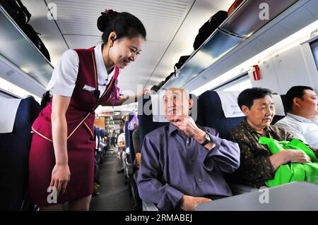 (140630) -- TIANJIN, 30 juin 2014 (Xinhua) -- un accompagnateur offre de l'aide à un passager à bord d'un train CRH qui circule sur le chemin de fer à grande vitesse Pékin-Shanghai, 30 juin 2012. Le chemin de fer à grande vitesse Beijing-Shanghai (ou Jinghu) a célébré lundi son troisième anniversaire d'exploitation. Le train à grande vitesse de 1 318 kilomètres qui relie Pékin, la capitale de la Chine, et Shanghai, la plus grande ville du pays, a accueilli plus de 220 millions de passagers au cours des trois années qui se sont écoulées depuis son entrée en service le 30 juin 2011. (Xinhua/Yang Baosen) (lmm) CHINE-PÉKIN-SHANGHAI-EXPLOITATION FERROVIAIRE À GRANDE VITESSE-ANNIVERSA Banque D'Images