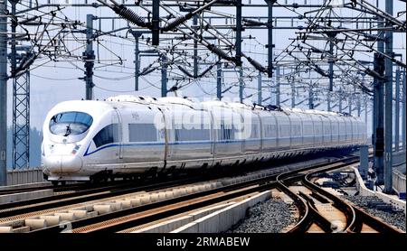 (140630) -- TIANJIN, 30 juin 2014 (Xinhua) -- Un train CRH qui circule sur le chemin de fer à grande vitesse Beijing-Shanghai quitte la gare sud de Tianjin, dans le nord de la Chine, Tianjin, le 30 juin 2012. Le chemin de fer à grande vitesse Beijing-Shanghai (ou Jinghu) a célébré lundi son troisième anniversaire d'exploitation. Le train à grande vitesse de 1 318 kilomètres qui relie Pékin, la capitale de la Chine, et Shanghai, la plus grande ville du pays, a accueilli plus de 220 millions de passagers au cours des trois années qui se sont écoulées depuis son entrée en service le 30 juin 2011. (Xinhua/Yang Baosen) (lmm) CHINE-PÉKIN-SHANGHAI-CHEMIN DE FER À GRANDE VITESSE-OPER Banque D'Images