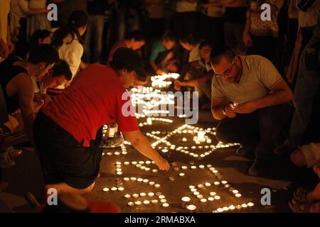 (140701) -- JÉRUSALEM, 30 juin 2014 (Xinhua) -- des Juifs allument des bougies à l'endroit où les trois adolescents israéliens ont disparu en Cisjordanie, le 30 juin 2014. Les forces de sécurité israéliennes ont découvert lundi soir les corps de trois adolescents israéliens portés disparus le 12 juin, près de Hébron en Cisjordanie, ont confirmé les militaires. Les corps d'Eyal Yifrach, de Naftali Frankel et de Gilad Shaer, 19 ans, tous deux âgés de 16 ans, ont été retrouvés dans les collines de Judée, dans le sud de la Cisjordanie, au nord d'Hébron, entre les villes palestiniennes de Beit Ummar et Halhul. Leurs corps ont été découverts dans une zone controlle Banque D'Images