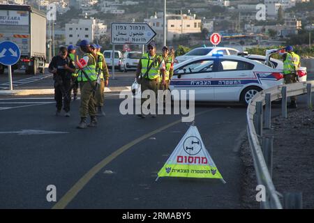 (140701) -- HÉBRON, 30 juin 2014 (Xinhua) -- des membres des forces de sécurité israéliennes se tiennent à côté de leurs véhicules alors qu'ils bloquent l'entrée nord du village de Halhul, près de la ville d'Hébron en Cisjordanie, le 30 juin 2014. Lundi, les corps des trois Israéliens enlevés il y a plus de deux semaines ont été découverts par les forces de sécurité juste au nord d'Hébron. Et après la découverte des trois corps israéliens, l'armée israélienne a bloqué toutes les entrées d'Hébron. (Xinhua/Mamoun Wazwaz) MIDEAST-HEBRON-MILITARY PUBLICATIONxNOTxINxCHN Hebron juin 30 2014 XINHUA membres d'Israe Banque D'Images