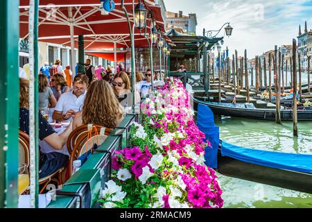 Venise, Italie - Mai 30 2023 : café-restaurant extérieur avec vue sur le Grand Canal à Venise. Touristes se détendant et déjeunant. Banque D'Images