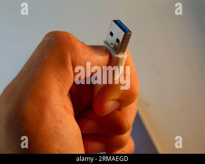 Une photo de la main d'un garçon blanc tenant une clé USB. Banque D'Images