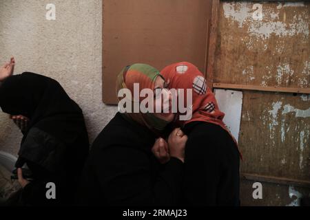 (140712) -- Gaza, 12 juillet 2014 (Xinhua) - des proches du militant palestinien du Jihad islamique Mohammed Sweilem, tué dans une frappe aérienne israélienne, pleurent lors de ses funérailles au camp de réfugiés de Jabalya, dans le Nord de la bande de Gaza, le 12 juillet 2014. Israël a pilonné des militants palestiniens dans la bande de Gaza samedi pour un cinquième jour, tuant neuf personnes, dont deux femmes handicapées, ont déclaré des médecins. Le ministère palestinien de la Santé a déclaré dans un communiqué de presse que depuis le début de l’offensive israélienne sur la bande de Gaza tôt mardi, 121 Palestiniens ont été tués et plus de 900 blessés. (Xinhua/Wissa Banque D'Images