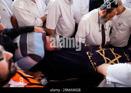 (140716) -- JÉRUSALEM, 16 juillet 2014 (Xinhua) -- des proches du civil israélien tué Dror Hanin pleurent lors de ses funérailles dans un cimetière de Yahud, Israël, le 16 juillet 2014. Les tirs de roquettes depuis Gaza ont tué mardi le civil israélien près du point de passage d'Erez à la frontière de Gaza, la première victime israélienne depuis qu'Israël a lancé son opération bordure protectrice la semaine dernière, ont déclaré des responsables israéliens. L'homme de 30 ans a été mortellement blessé par une roquette qui a frappé le point de passage d'Erez et est mort de ses blessures peu après, a déclaré un porte-parole de l'armée israélienne à Xinhua. (XINHUA/JINI) ISRAEL-YAHUD-EREZ CROS Banque D'Images