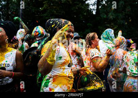 Le 27 août 2023, des centaines de milliers de fêtards célèbrent le premier jour du Carnaval à Notting Hill, West London, Angleterre en lançant du p coloré Banque D'Images