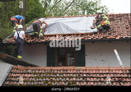 Bad Bayersoien, Allemagne. 27 août 2023. Après la tempête dans le quartier de Garmisch-Partenkirchen, le toit d'un immeuble résidentiel est provisoirement recouvert de bâches. En raison de graves dégâts causés par la tempête, le bureau de district de Garmisch-Partenkirchen a déclaré dimanche une situation catastrophique pour la ville, qui compte environ 1 300 habitants. 80 % des bâtiments de la ville seraient gravement endommagés. Crédit : Felix Hörhager/dpa/Alamy Live News Banque D'Images