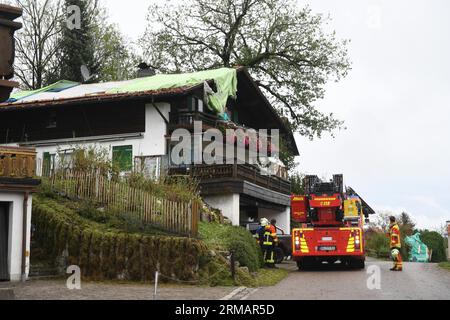 Bad Bayersoien, Allemagne. 27 août 2023. Après la tempête dans le quartier de Garmisch-Partenkirchen, le toit d'un immeuble résidentiel est provisoirement recouvert de bâches. En raison de graves dégâts causés par la tempête, le bureau de district de Garmisch-Partenkirchen a déclaré dimanche une situation catastrophique pour la ville, qui compte environ 1 300 habitants. 80 % des bâtiments de la ville seraient gravement endommagés. Crédit : Felix Hörhager/dpa/Alamy Live News Banque D'Images